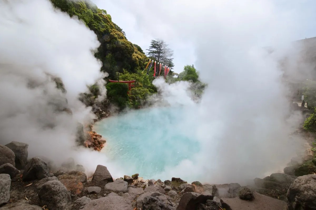 Dampende turquoise warmwaterbron met een torii in Hakone