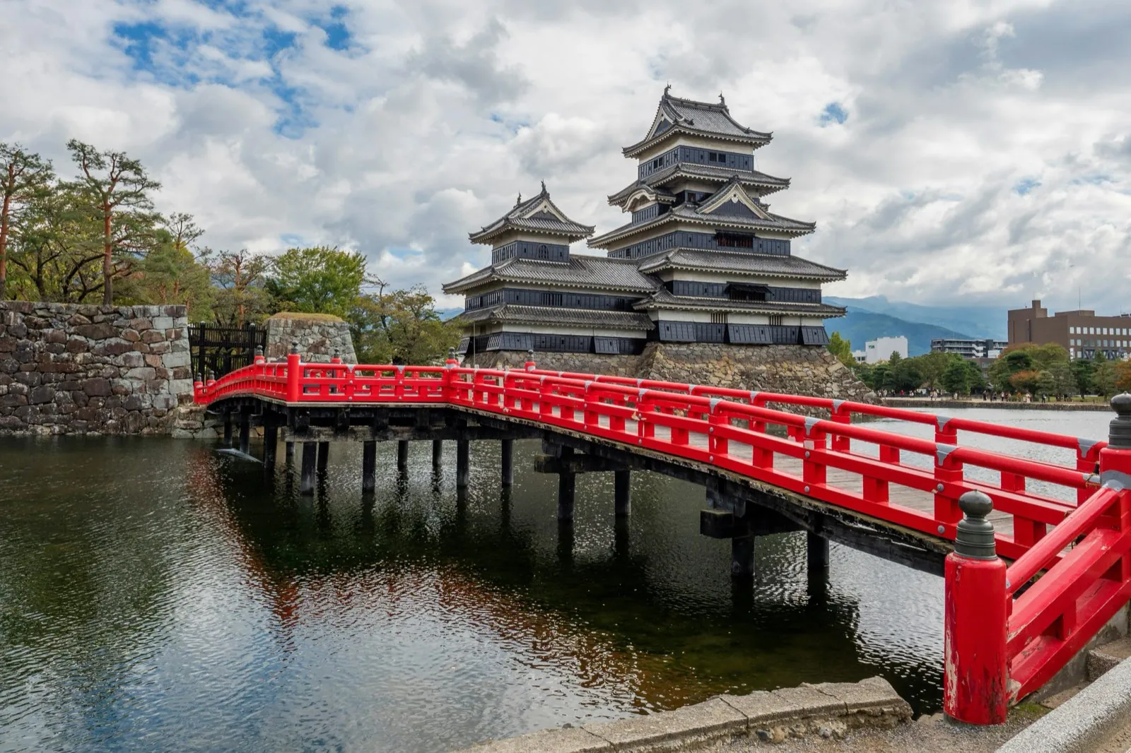 Kasteel van Matsumoto met zijn zwarte toren en de rode brug over de gracht, in de prefectuur Nagano